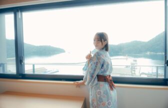 海の見える宿で窓辺から海を眺める女性
