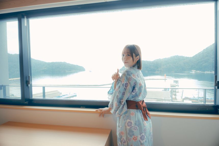 海の見える宿で窓辺から海を眺める女性